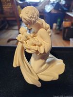 Front view of ceramic mother holding infant