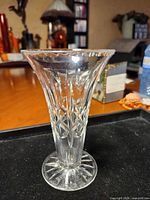 Side view of clear pressed glass vase showing pattern and shape