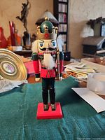 Front view of painted wooden nutcracker soldier on red base