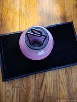 Top view of assembled lantern showing rose glass globe and black metal handle