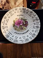 Front of plate showing floral design, Happy Anniversary text, gift year list, gold trim