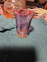 Shot glass upright showing pink iridescent color and gold base
