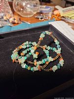 Bracelet coiled inside display box showing mixed gemstone chips and glass beads