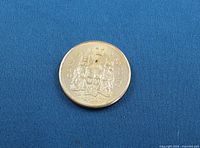 Reverse of 1963 Canadian 50-cent coin showing coat of arms and drilled hole