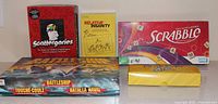 Group shot of five boxed games: Scattergories, Relative Insanity, Scrabble, Battleship, Pictionary Air