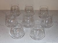 Eight clear stemless wine glasses grouped together