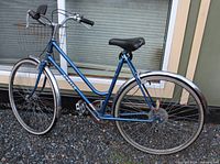 Full view of blue Apollo step-through bicycle with basket, fenders and wheels