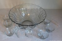 Clear ribbed glass punch bowl with eight matching punch cups and glass ladle