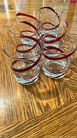 Six red swirl tumblers grouped on wooden surface
