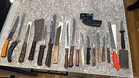 Full layout of knives, sharpener, honing steel and stone on countertop