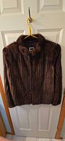 Front view of brown mink fur jacket on hanger