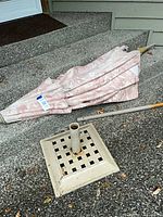 Umbrella folded next to square lattice stand