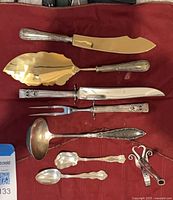 All eight utensils laid on red cloth