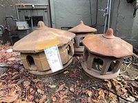 Three miniature terra cotta chimney tops outdoors
