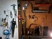 Overall view of pegboards showing saws, clamps, garden tape spool