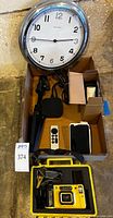 Overall lot with wall clock, Apple TV, remote, cables, tripod, smartphone, Minolta camera in yellow case