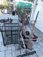 Overall view showing utility cart, two hand trucks, rake, squeegee, cultivator