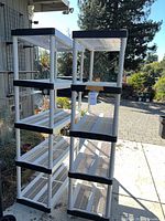 Two plastic 5-tier shelving units outdoors
