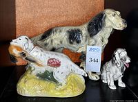 Three dog figurines including Ezra Brooks decanter and two unmarked dogs