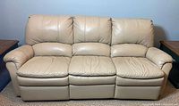 Front view of beige faux leather 3-seat sofa upright