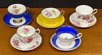 Front view of five teacup and saucer pairs
