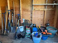 Overall view of long-handled tools, pots, and accessories in shed