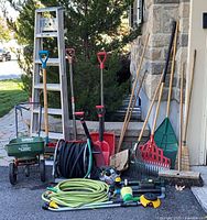 entire group of lawn tools, hoses, ladder, spreader and sprinklers