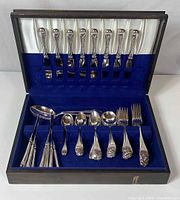 Flatware set displayed in open wooden chest