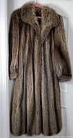 Front view of full-length raccoon fur coat on hanger