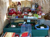 Overall view of table holding assorted Christmas décor, ornaments, figurines, pillows and storage totes