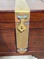 Close-up of brass strap and latch on chest front