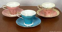 Front view of three teacup and saucer duos