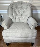 Front view of light gray-beige tufted armchair