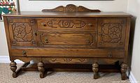 Front view of dresser showing carved panels, drawers, legs and stretcher