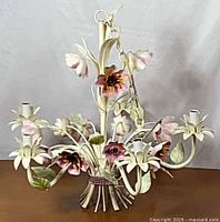 front view of ivory and pink floral tole chandelier with five light sockets and hanging chain