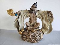 Front view of Shiwan clay figurine showing pose, fan, robe, and base details