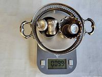 All scrap silver items on scale reading 0.099 kg (99 g)