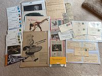 Overview of entire lot laid out on floor showing cards, ads, tickets, pennant and covers