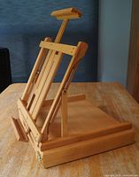 Side angle of wood tabletop easel showing adjustable mast and folded base