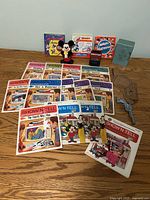 All items laid out: 13 Show'N Tell sets, 5 banks, toy revolver, cardboard rifle & holster