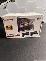 Front of Moajerry Lite box with 4K Ultra HD and image of two controllers