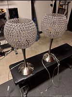 Two Luminaire crystal table lamps side by side on bench