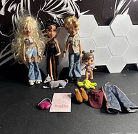 Group shot of four Bratz dolls with accessories arranged in front