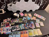 Overview of scattered trading cards from three franchises on tabletop