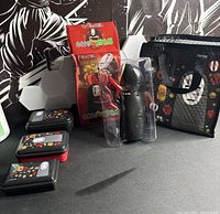 Entire lot showing figure in package, tote bag, three containers