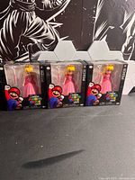 Front view of three boxed Princess Peach figures
