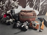 Overall view of two cameras, five lenses, two lens cases, camera bag, strap