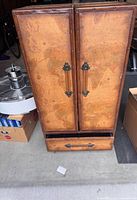 Front view of cabinet showing world map exterior, doors, lower drawer