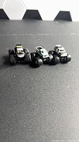 Front view of three micro monster trucks side by side