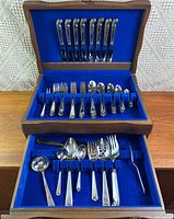 Full set in two-tier chest showing place settings and serving pieces